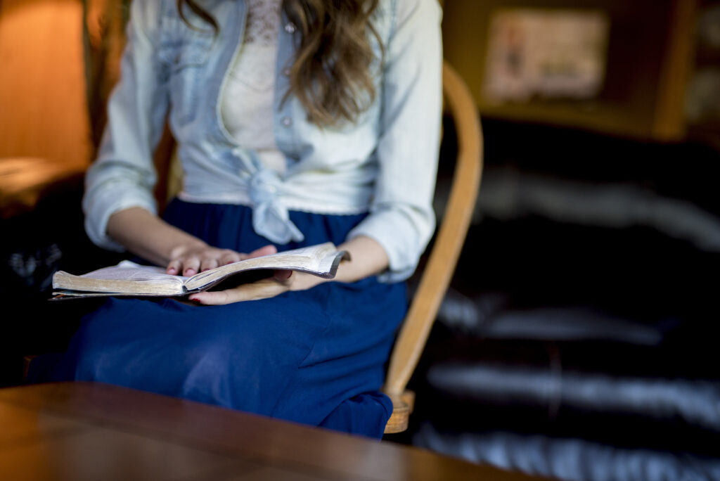 Woman in skirt reading Bible